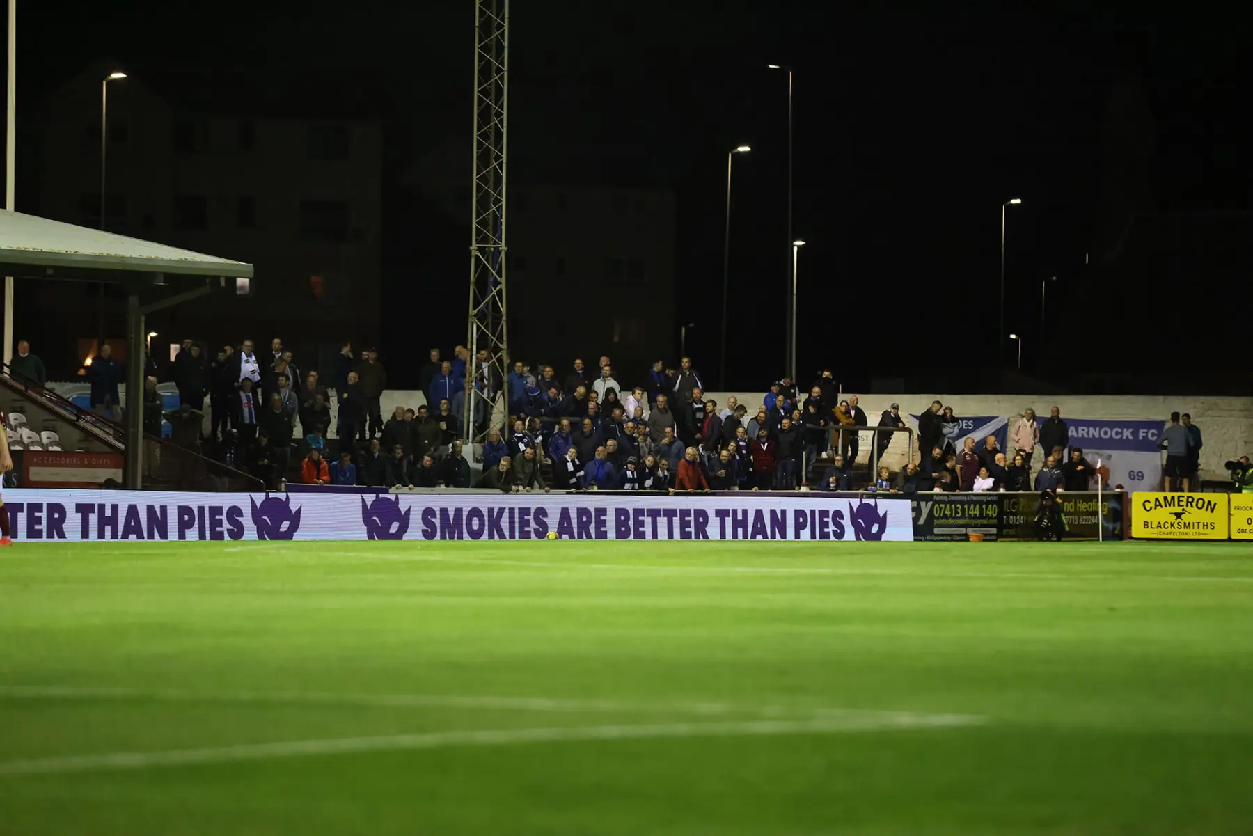A Purple Imp pitchside LED board at a floodlit Scottish football ground: Smokies are better than pies